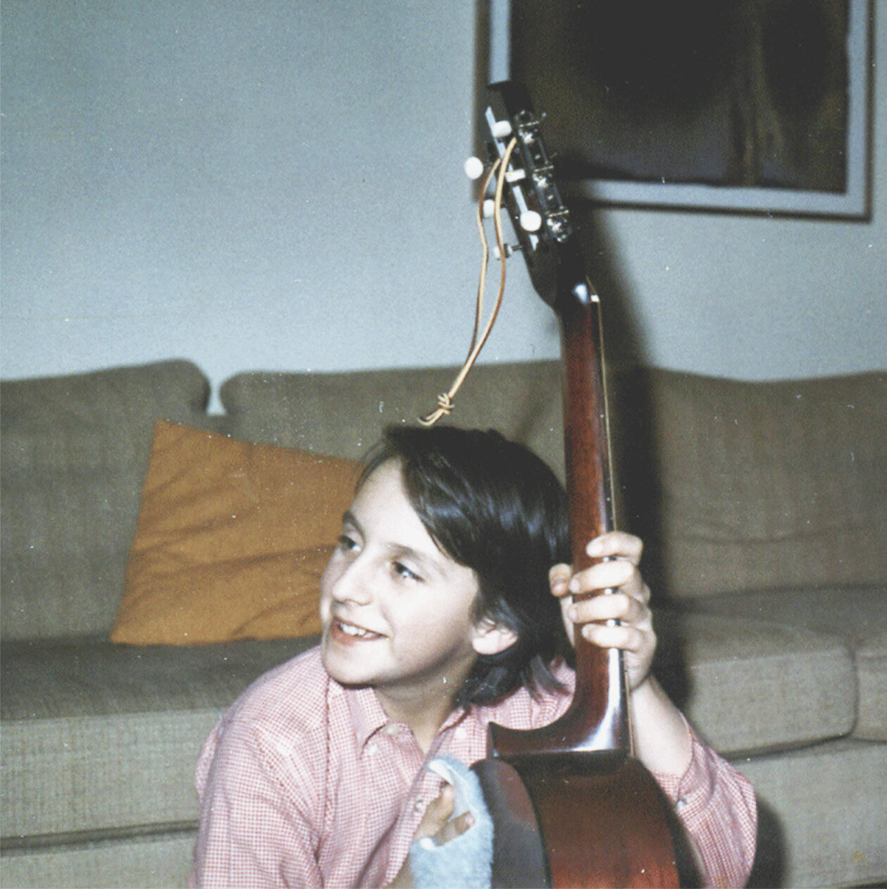 An old photograph of the author holding a guitar